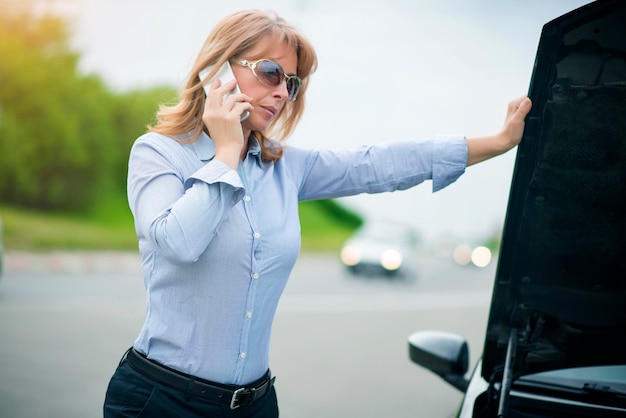 Rijpe vrouw met autopech