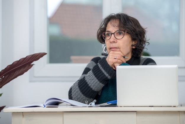 Rijpe vrouw peinzend in het kantoor