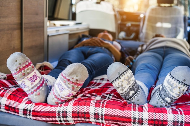 Rijpe vrouwen slapen in een minibusje met warme kerstsokken. Focus op voeten