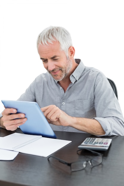 Rijpe zakenman met digitale tablet en calculator bij bureau