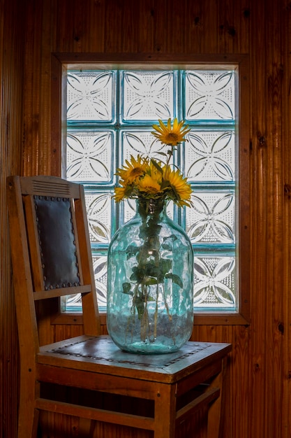 Rijpe zonnebloem in een glazen pot voor het raam