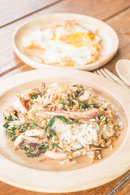 Rijst gegarneerd met geroerbakte inktvis-basilicum en gebakken ei (Thais eten)