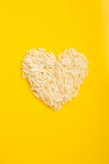 Rijst in hartvorm op gele achtergrond