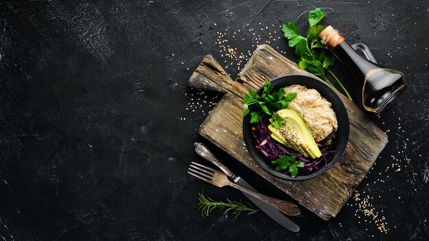 Rijst met avocado en kool Gezonde voeding Bovenaanzicht Op een zwarte achtergrond Gratis kopieerruimte