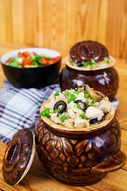 Rijst met kip, champignons en olijven op houten