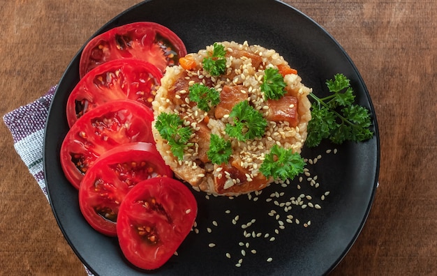 Rijst met vlees, groenten en tomaten op een bord