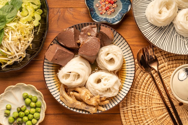 Rijstnoedels of Rijstvermicelli in viscurrysaus met bloedtofu en Kippenpootjes