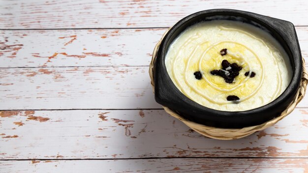 Rijstpudding in een zwarte kleiplaat op een houten bankje een zeer smakelijke post