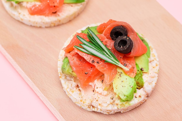 Rijstwafelsandwiches met verse zalm, avocado en olijven