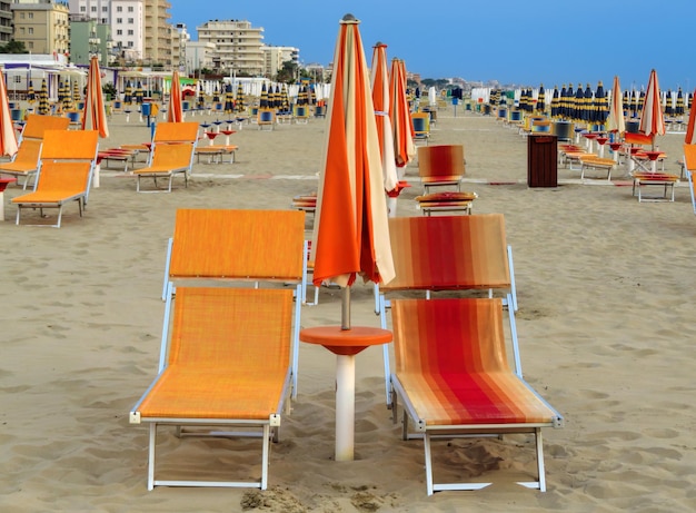 Rimini Orange parasols en ligbedden