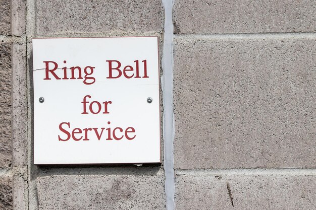 Ring bell for service sign on a wall