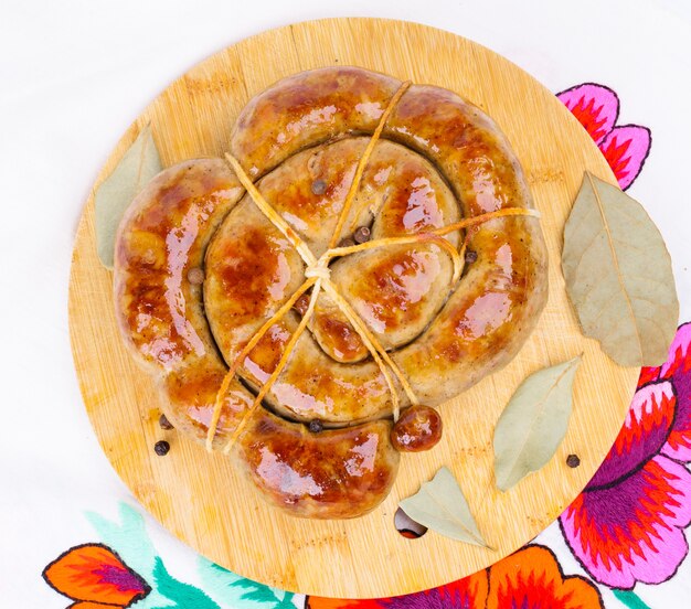 Ring fried sausage on a wooden cutting board.