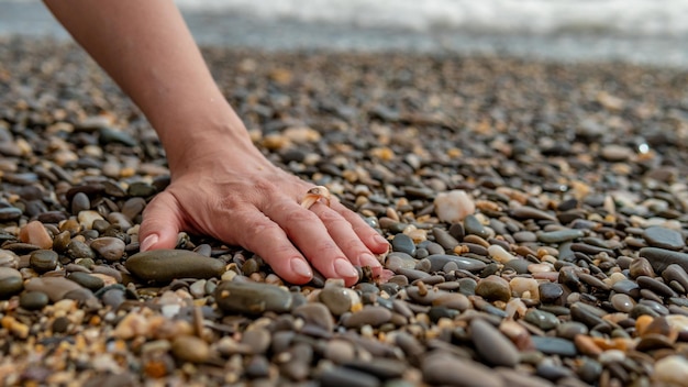 Ring at sea on hand put on a sea ring of water on a rocky beach idea for a photo