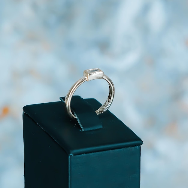 a ring sits on a box with a blue background.