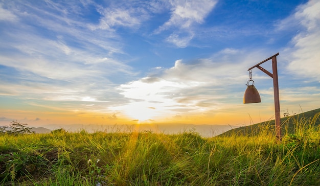 Photo ringing bell on top of mountain with sunset and blue sky scene