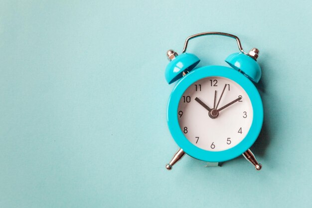 Ringing twin bell vintage classic alarm clock Isolated on blue pastel colorful trendy background Rest hours time of life good morning night wake up awake concept Flat lay top view copy space