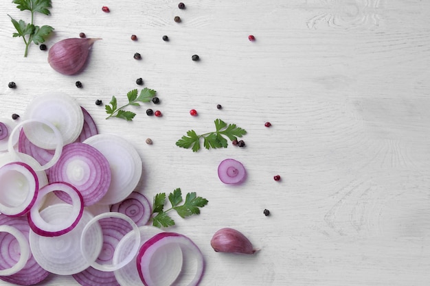 Rings cut into red onions with herbs and spices on a white wooden table. vegetables. top view