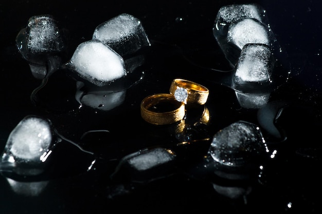 Rings on a dark background. Wedding rings. Jewelry. Ice