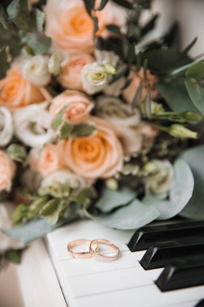 Rings lie on the piano keys against the background of a bouquet