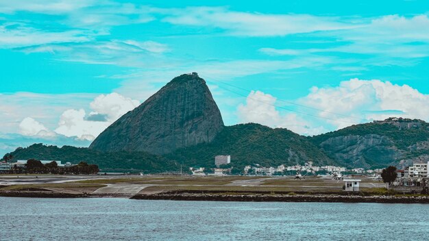 Rio de janeiro brazil - circa 2021 photo of sugarloaf mountain pao de acucar with santos dumont airport runway and guanabara bay during the day