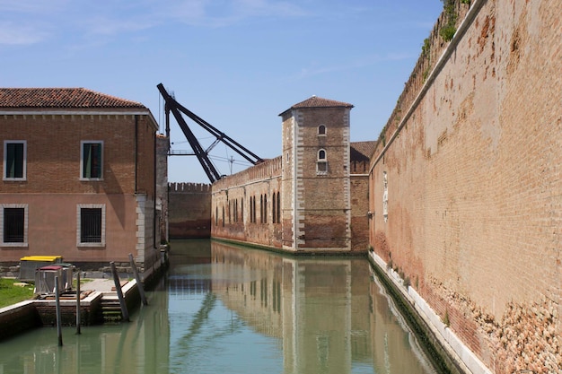 Foto rio de le vergini a venezia con le mura storiche dell'arsenale