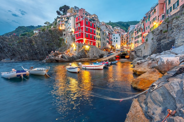 Villaggio di pescatori di riomaggiore durante l'ora blu del crepuscolo serale, vista sul mare in cinque terre, parco nazionale delle cinque terre, liguria, italia.