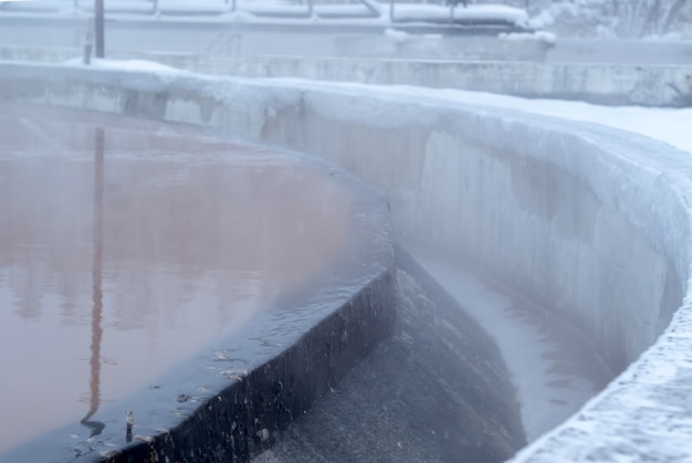 Rioolwaterzuiveringsinstallatie in de winter, ijzige primaire bezinkingstanks