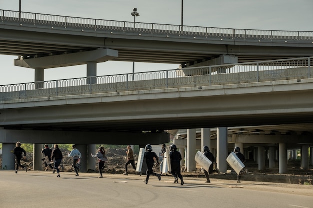 ОМОН со щитами бежит под мосты за молодых нарушителей закона, чтобы поймать их и арестовать