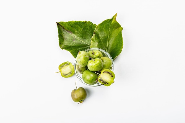 Ripe Actinidia arguta or kiwi isolated on white background. Branches of fresh fruits with green leaves, mockup, template