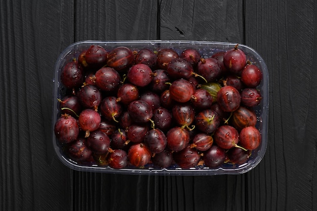 Ripe agrus or gooseberry on a dark wooden background