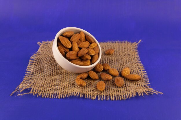 Ripe almonds scattered on a blue background