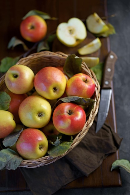 Ripe apples in a basket with leaves around it