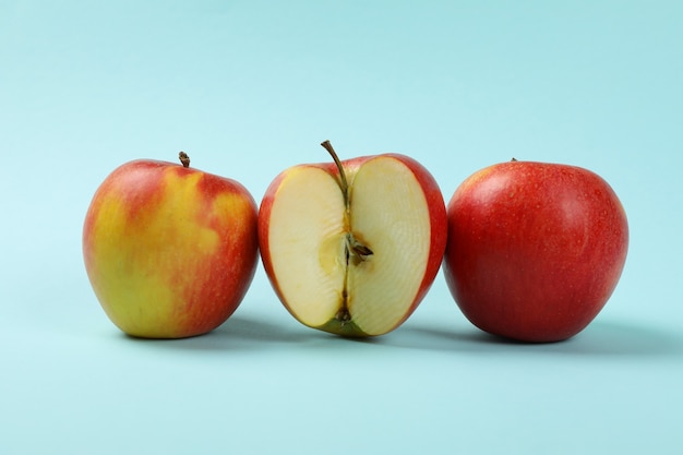 Ripe apples on blue, close up