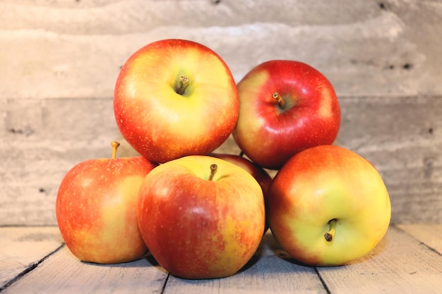 Ripe apples lie on the table in a bunch