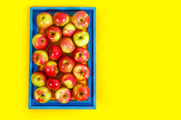 Ripe apples on a yellow background