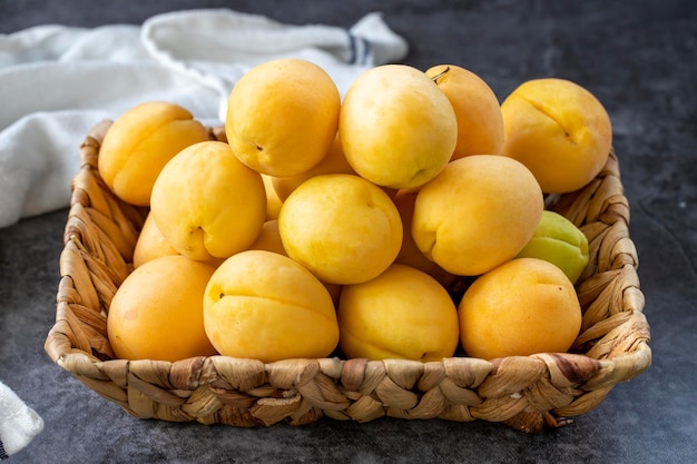 Ripe apricots on a dark background Fresh and juicy apricots in the basket Organic food close up