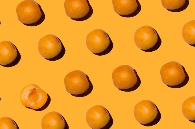 Ripe apricots and half on orange background