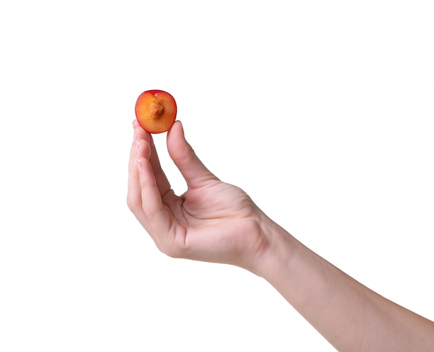 Ripe apricots in a hand on a white wall