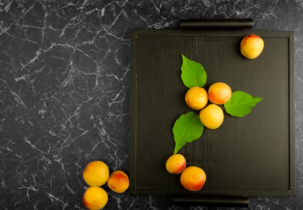 Ripe apricots lying on a black tray