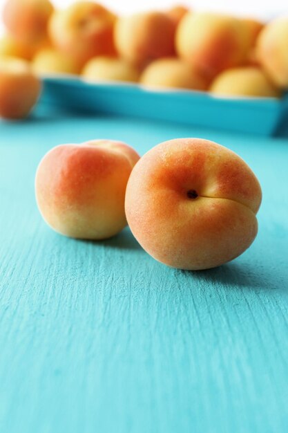 Photo ripe apricots on wooden table close up