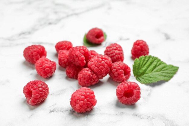 Ripe aromatic raspberries on marble table closeup