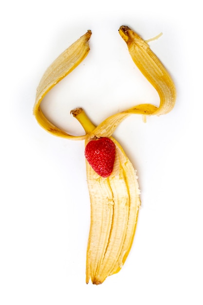 Ripe banana peel with strawberry berry on a white background