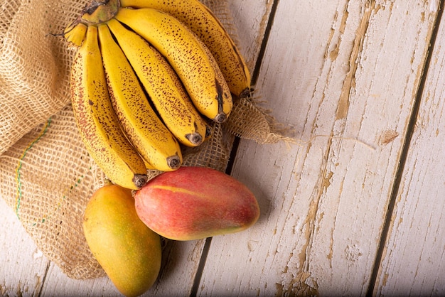 Ripe bananas and mangoes details of a bunch of very ripe bananas and some mangoes selective focus