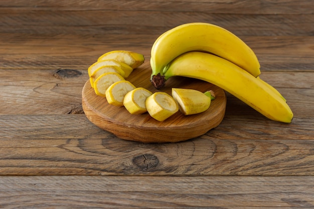 Ripe bananas on woodn background. Tasty healthy tropical fruits.