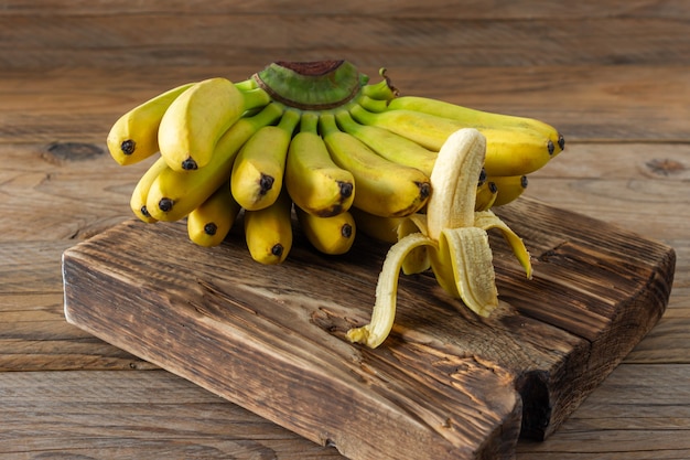 Ripe bananas on woodn background. Tasty healthy tropical fruits.