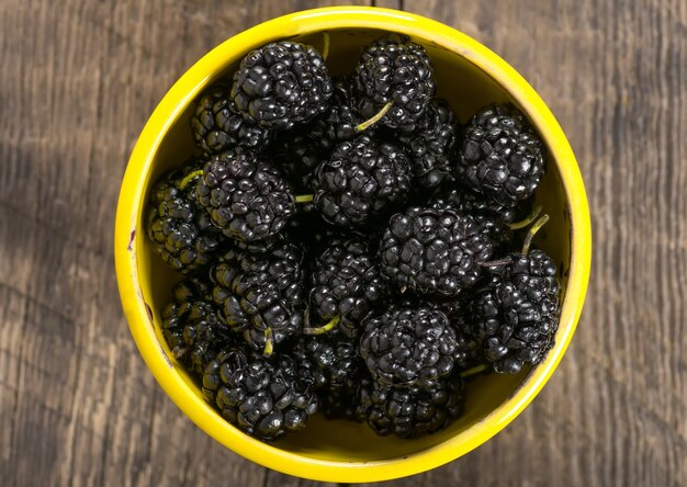 Ripe black mulberry in ceramic bowl