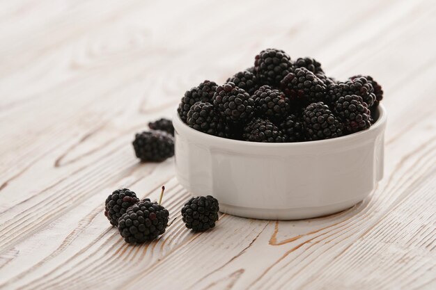 Ripe blackberries in bowls on the table