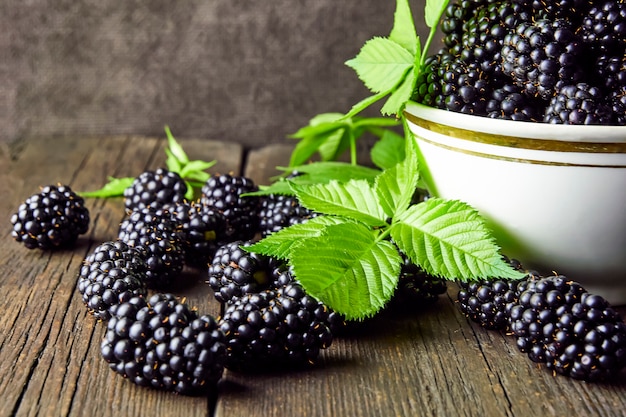 Photo ripe blackberries with leaves in a bowl