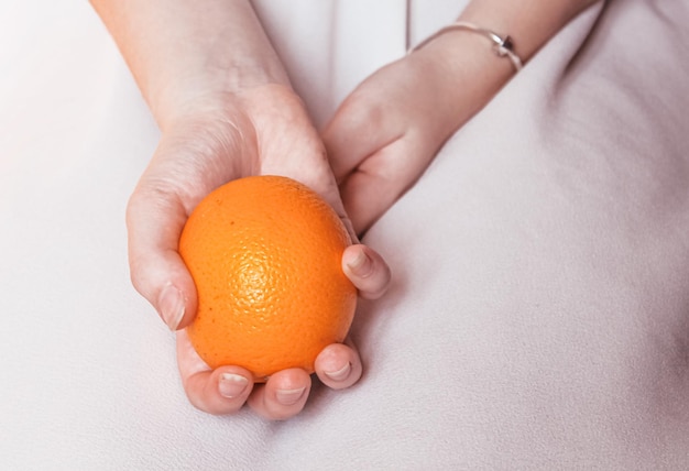 Ripe bright orange in tender female hands