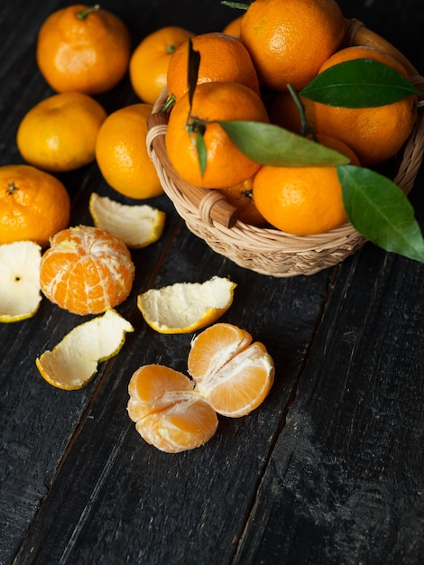 Ripe bright tangerines in a basket with leaves